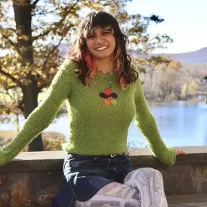 Lia Jacobs '24 sitting outside in front of Paradise Pond